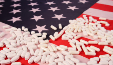 US flag with white pills scattered across it