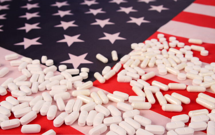 US flag with white pills scattered across it