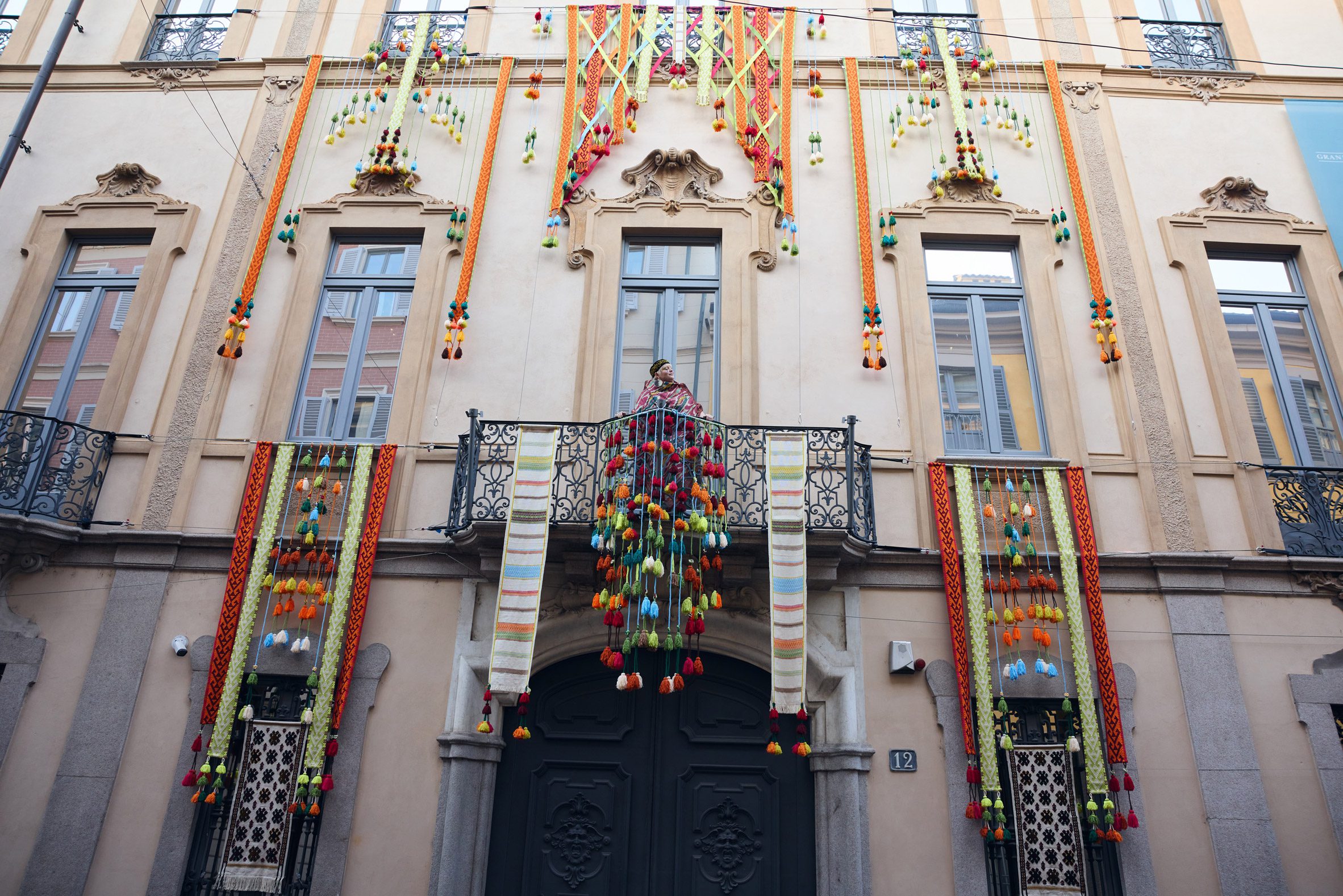 Facade of Palazzo Citterio decorated with colourful textile and tassel installations for the When Apricots Blossom exhibition