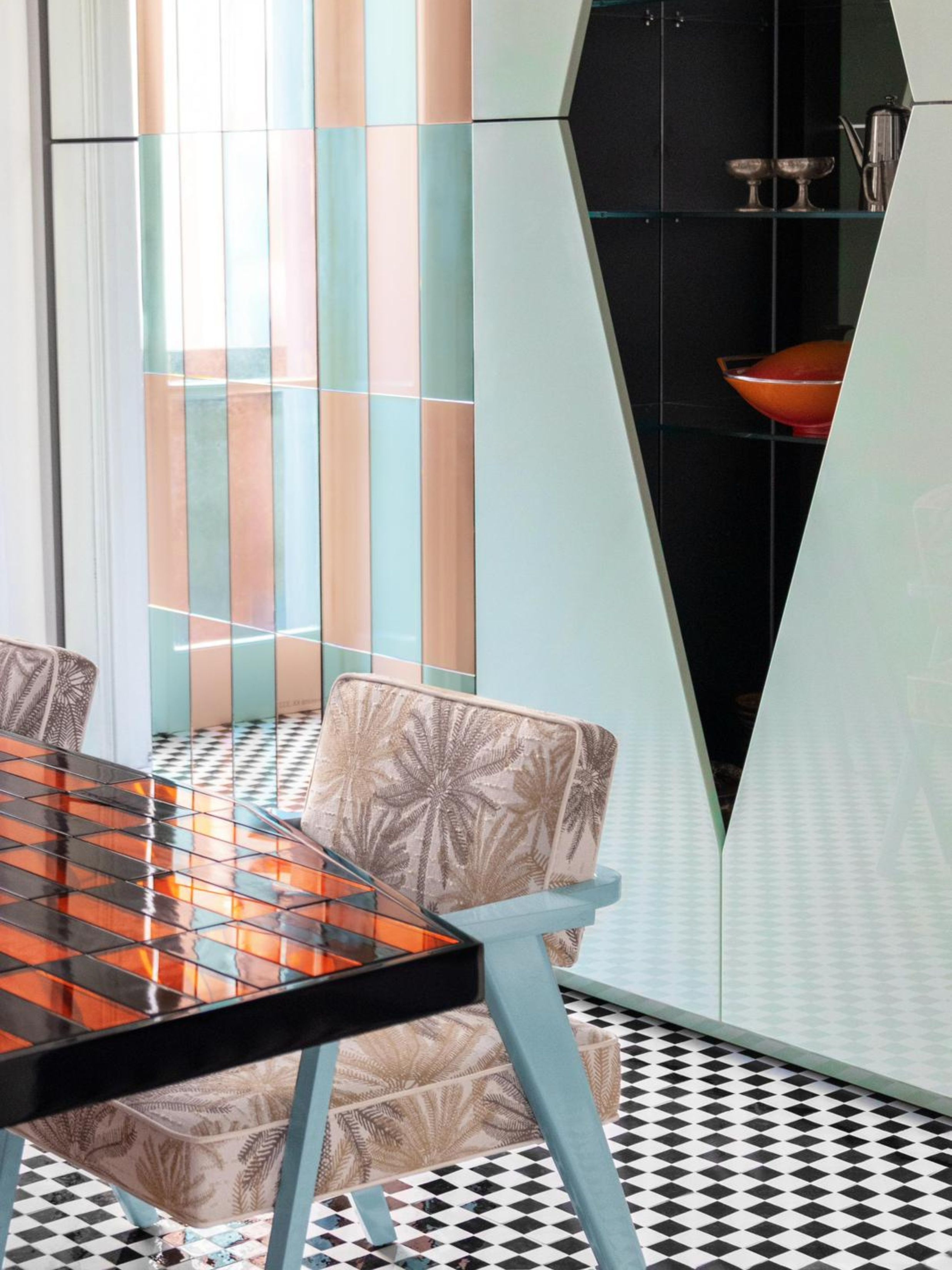 a light blue lacquer cabinet with a lacquer blue chair in front with a tiled table