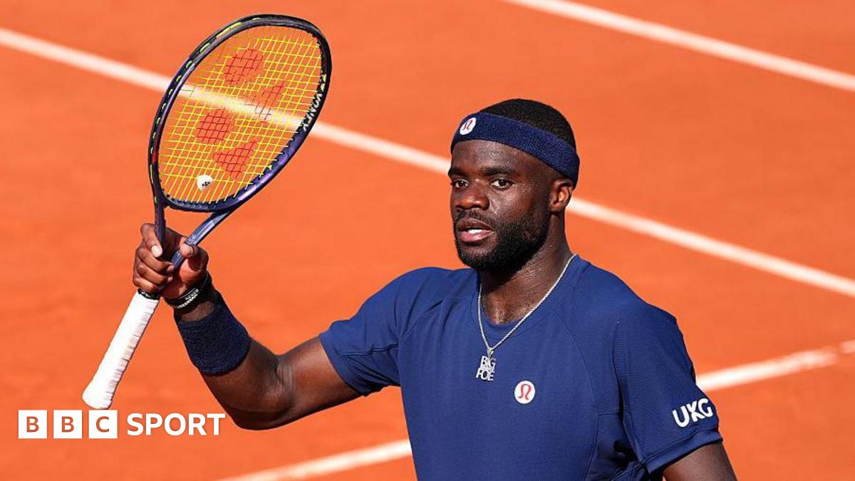 Frances Tiafoe raises his racquet at the French Open