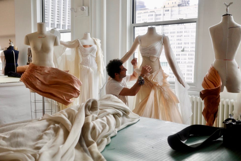 Fashion designer working on garments in a studio.