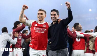 Leandro Trossard and Mikel Arteta celebrating on the Emirates Stadium pitch after beating Atletico Madrid.