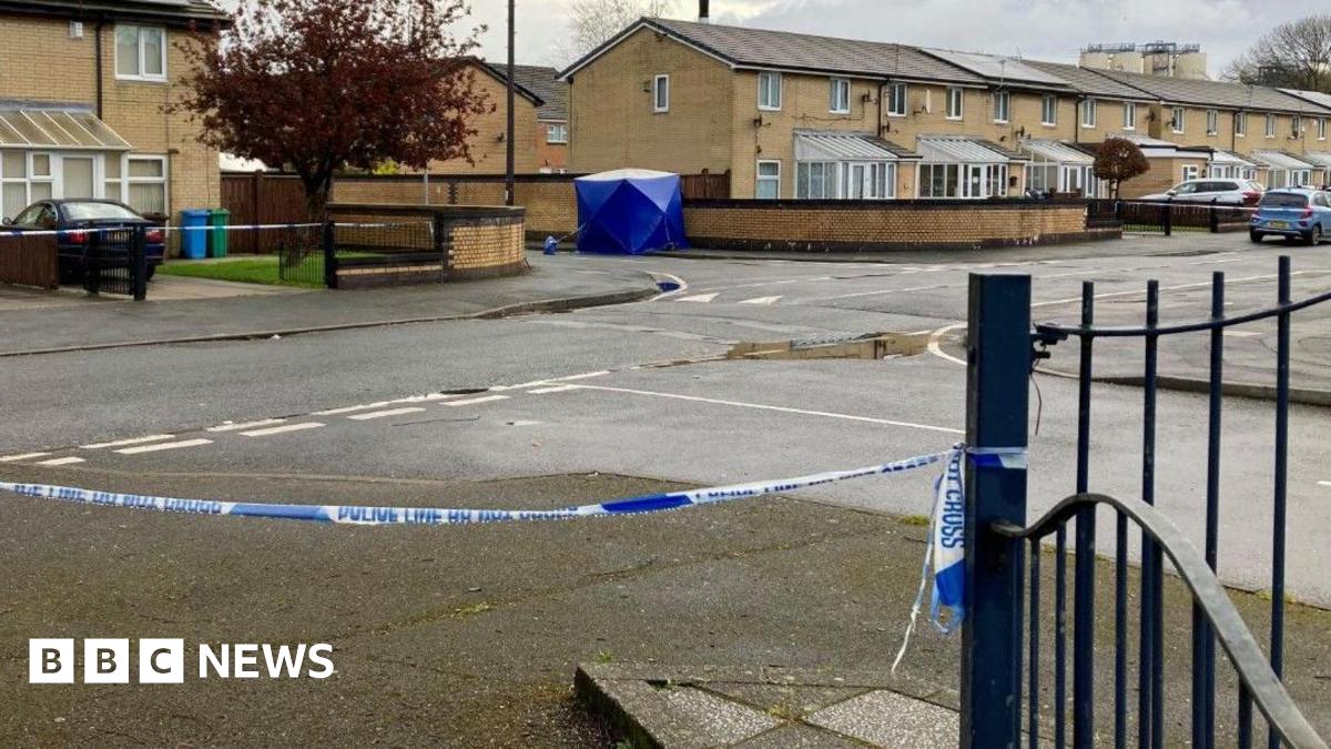Crime scene on a residential street sealed off with blue-and-white police tape