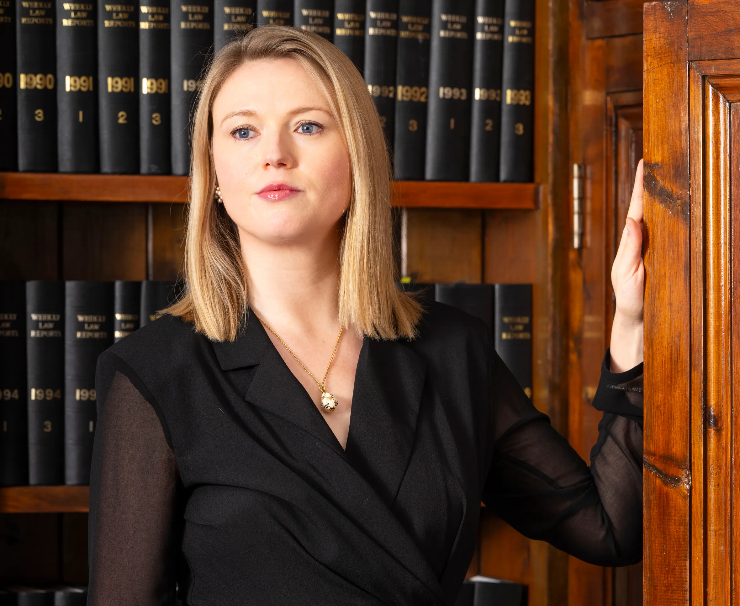 Charlotte Proudman, a women's rights campaigner and family lawyer, stands in a room with legal books.
