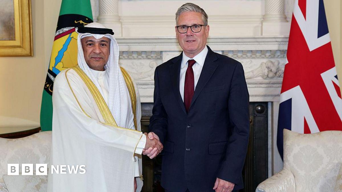 Keir Starmer and Jasem Mohamed Albudaiwi shaking hands in front of a marble fireplace in Downing Street. The UK and GCC flags are behind them.