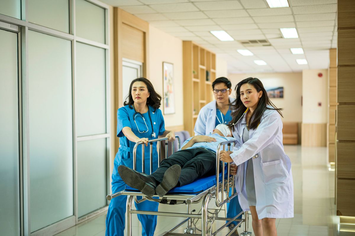Medical team rushing patient man in a stretcher down. Hospital emergency. File image