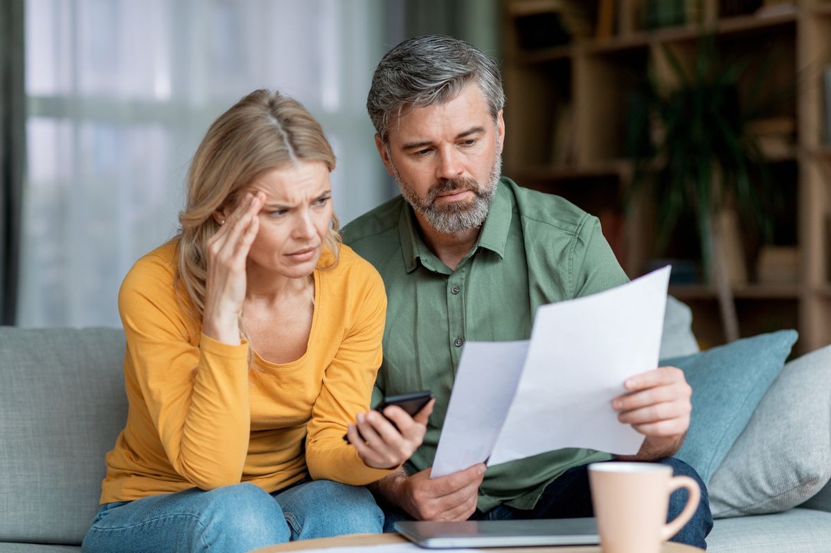 Middle aged couple looking stressed while planning budget