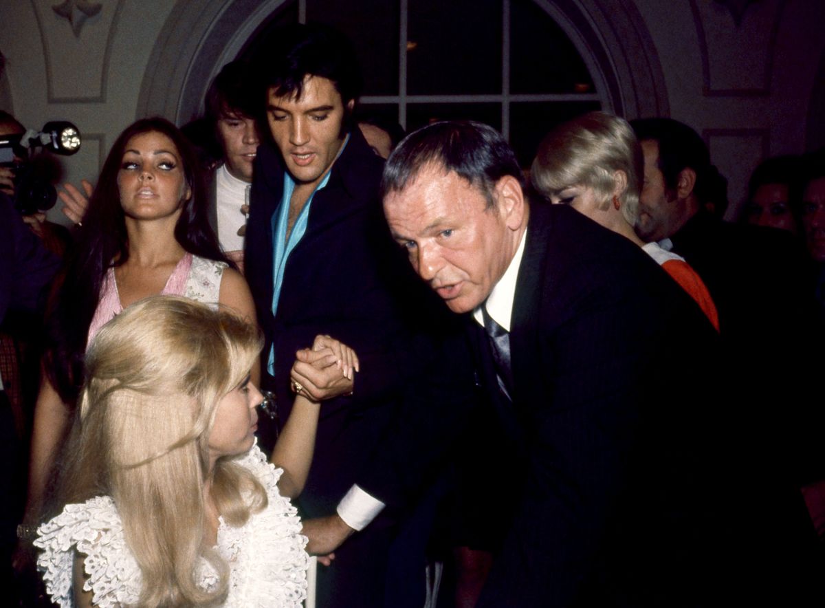 American actress Priscilla Presley and Elvis Presley look on as American singer Frank Sinatra (1915 - 1998) talks to his daughter Nancy Sinatra during an event in Las Vegas, Nevada, circa 1969
