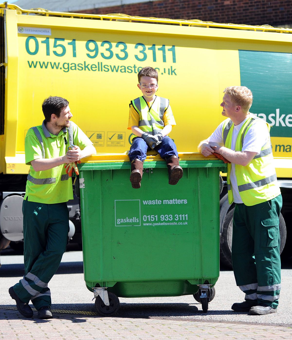 Six-year-old Daniel helps Refuse Technicians Barry Woodward (R) and Danny Doyle