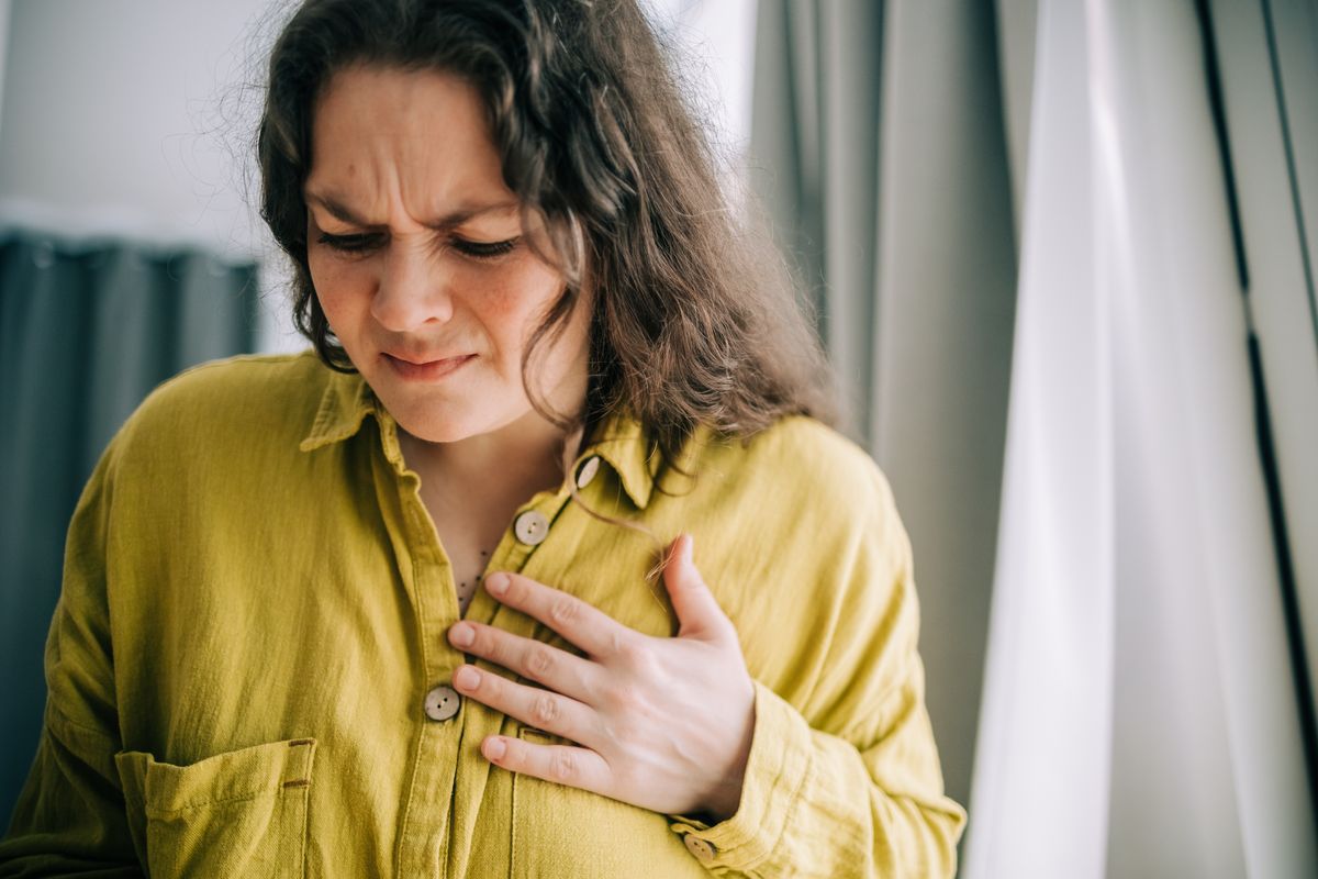 Woman suffering from chest pain holding hand over heart