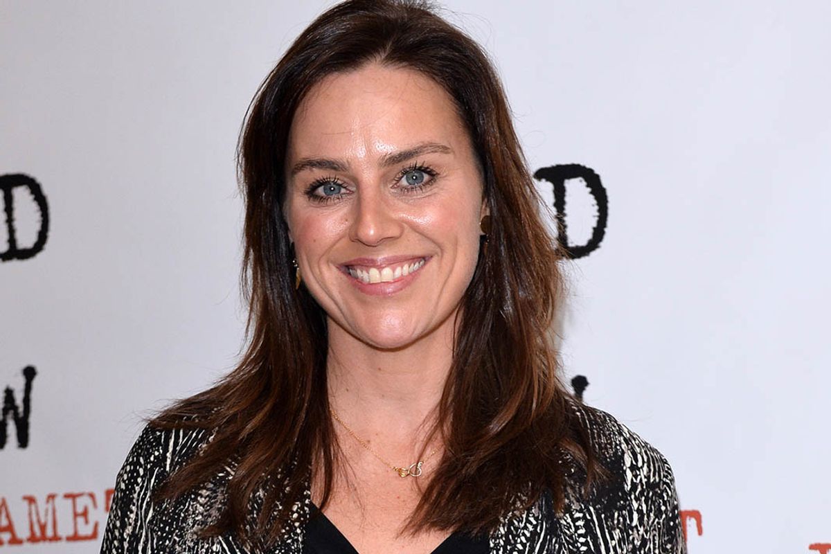 A woman smiles in a promotional setting
