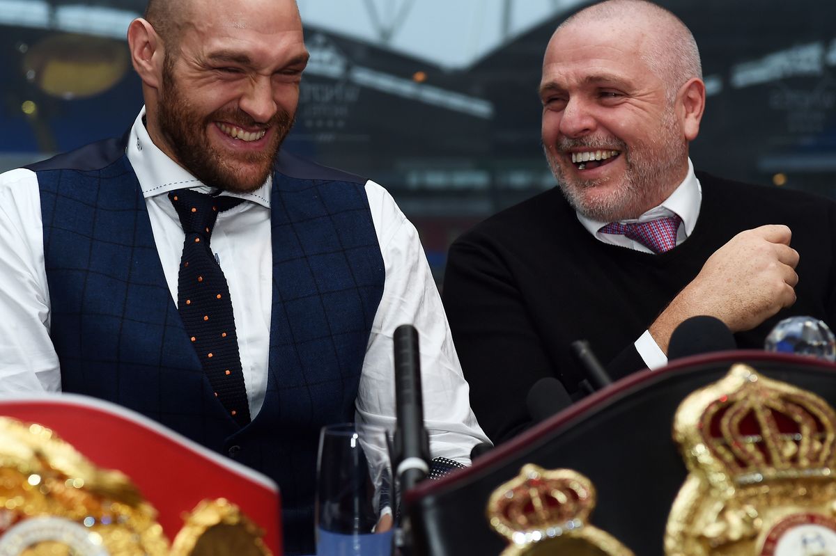 Britain's world heavyweight champion Tyson Fury (L) takes part in a press conference with his uncle and trainer Peter Fury in Bolton, north west England on November 30, 2015.