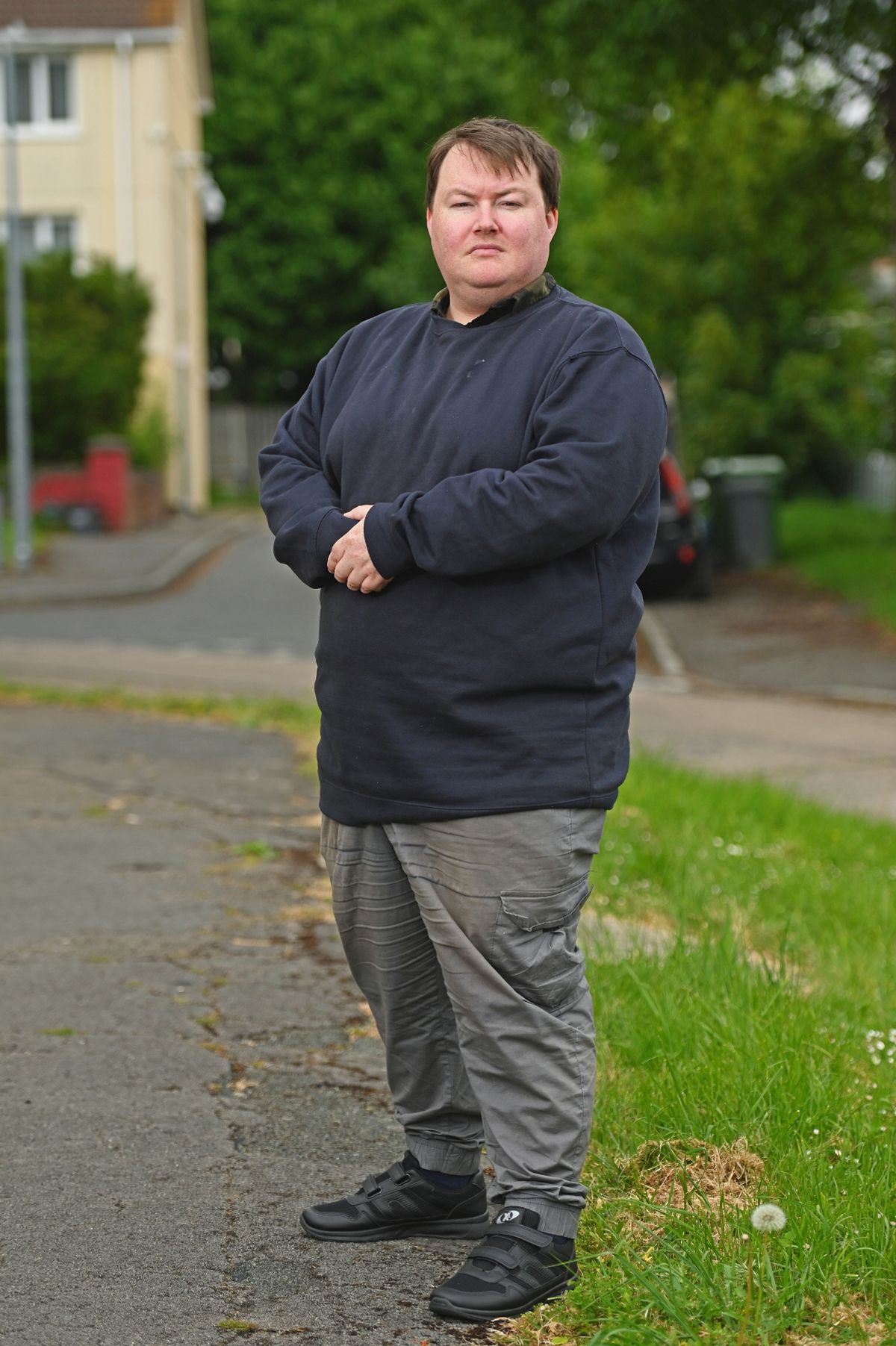 Man standing in street with hands clasped in front