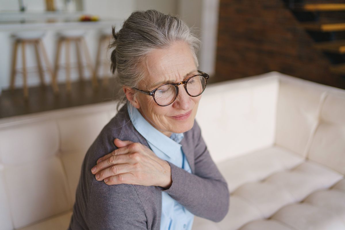 Senior woman suffering from shoulder pain at home, elderly health problem, joint discomfort, muscle strain, limited mobility, healthcare concept, rehabilitation, recovery and medical support need