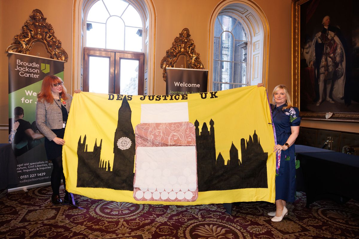 Suzanne Massey (right) holding the DES Justice UK banner, with her colleague (left), at Liverpool Town Hall