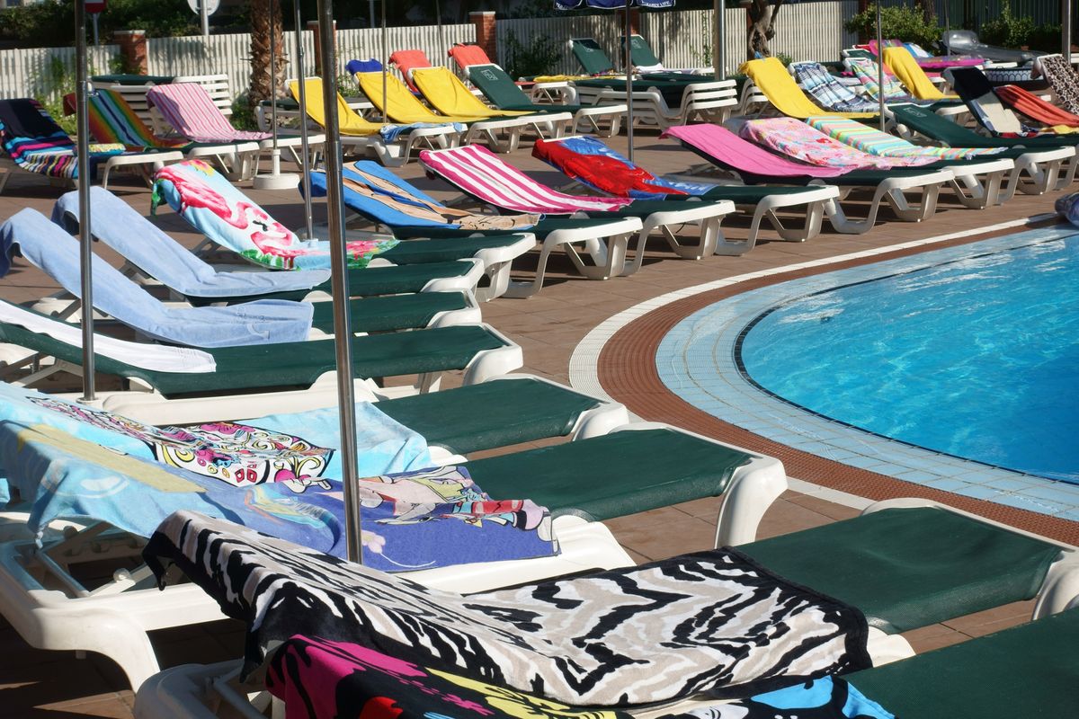 Towels on sunbeds around a pool