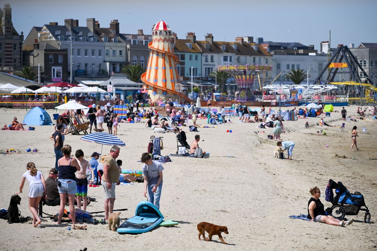 Visitors enjoy the hot weather on Weymouth beach, on May 21, 2026 in Weymouth, England