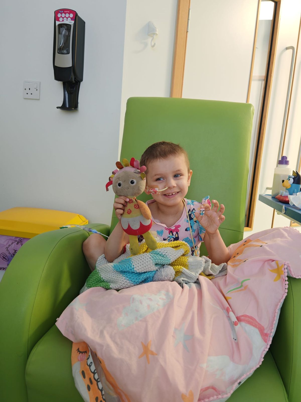 Holly with her comfort rainbow blanket and teddy Upsy Daisy