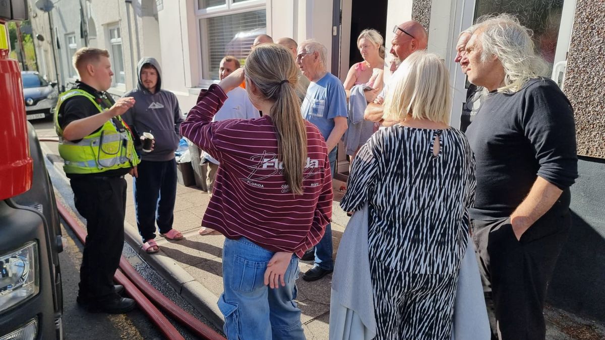 People gathered around a police officer providing them with instructions