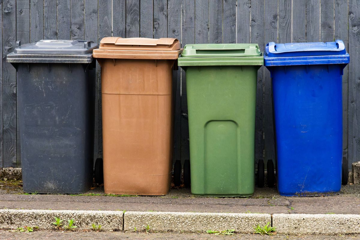 Wheelie bins in row segregated for recycling rubbish UK