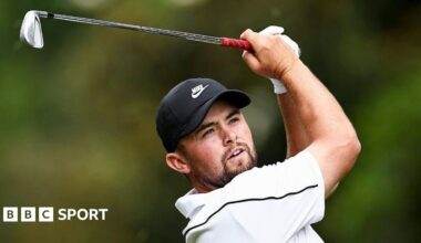 Alex Fitzpatrick watches his ball after playing an iron shot, with the club above his head