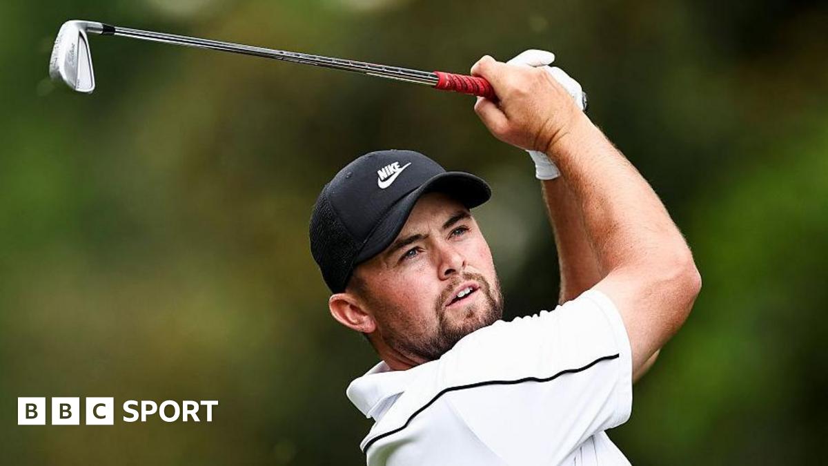 Alex Fitzpatrick watches his ball after playing an iron shot, with the club above his head