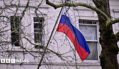 A Russian flag is visible through trees