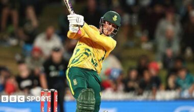 Jordan Hermann holds his bat in the air while wearing South Africa kit and batting during the IT20 match with New Zealand
