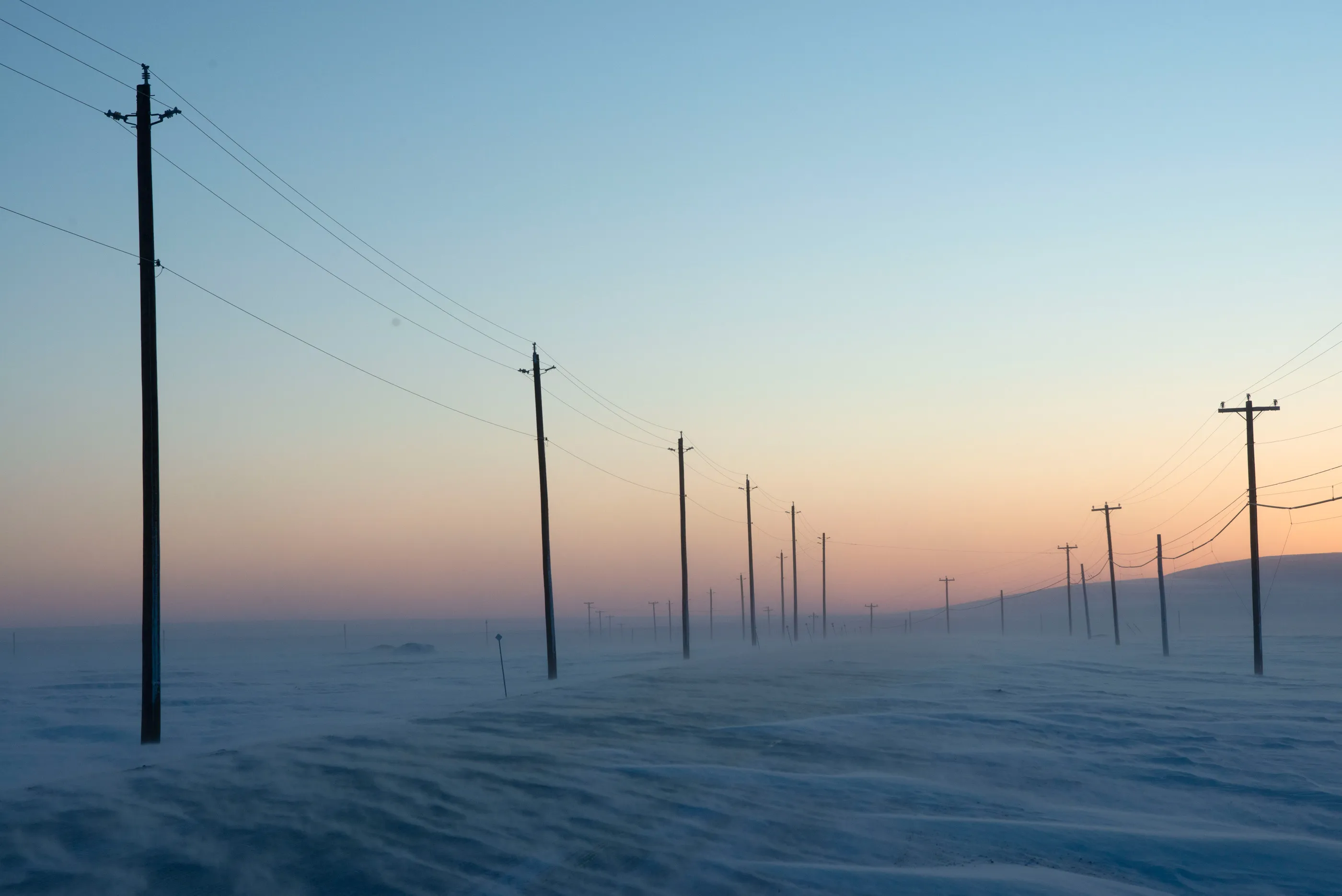 Diesel is used widely, including at the power station that feeds the power cables pictured here against the sunset across the barren snowy landscape.