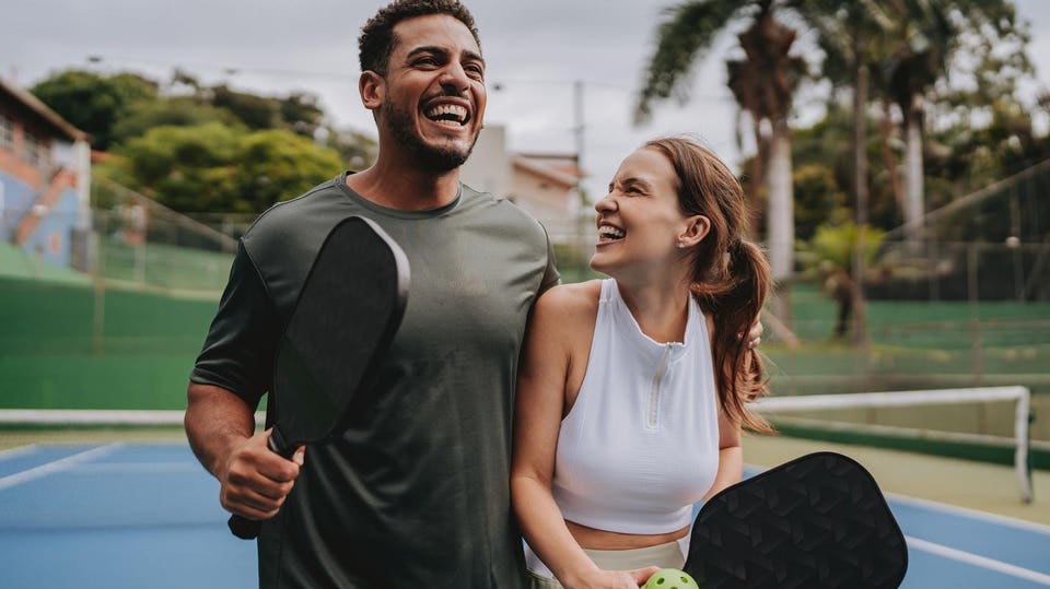 Couple playing pickleball celebrate point