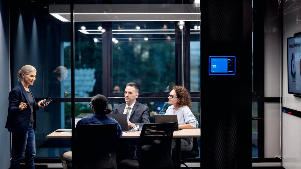Business professionals in a glass boardroom discussing AI in the workplaces
