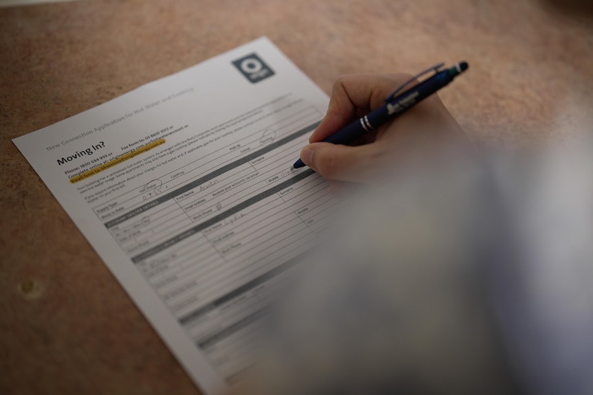 A woman signing a moving in document for a rental.