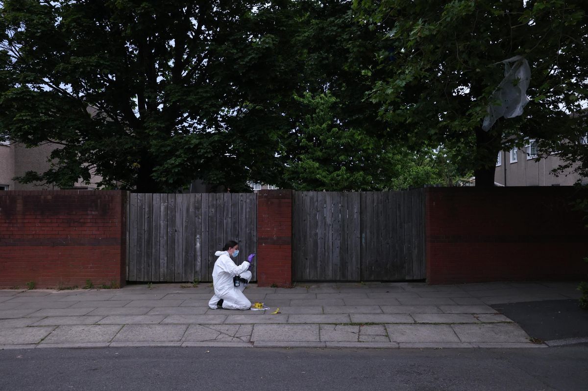A forensics officer taking evidence on the pavement