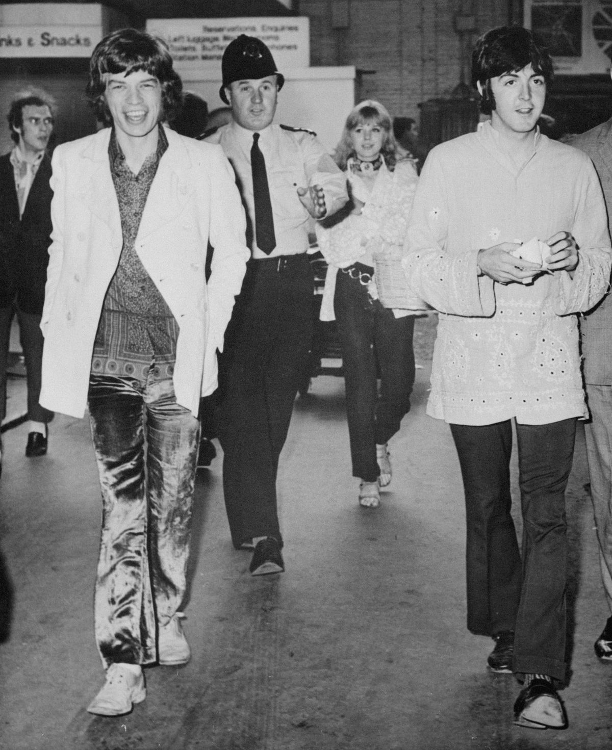 All aboard the "love" train...Beatle Paul McCartney, wearing an Indian-style jacket, and Mick Jagger (left) of the Rolling Stones, walk toward train en route to a love pilgrimage to Bangor.