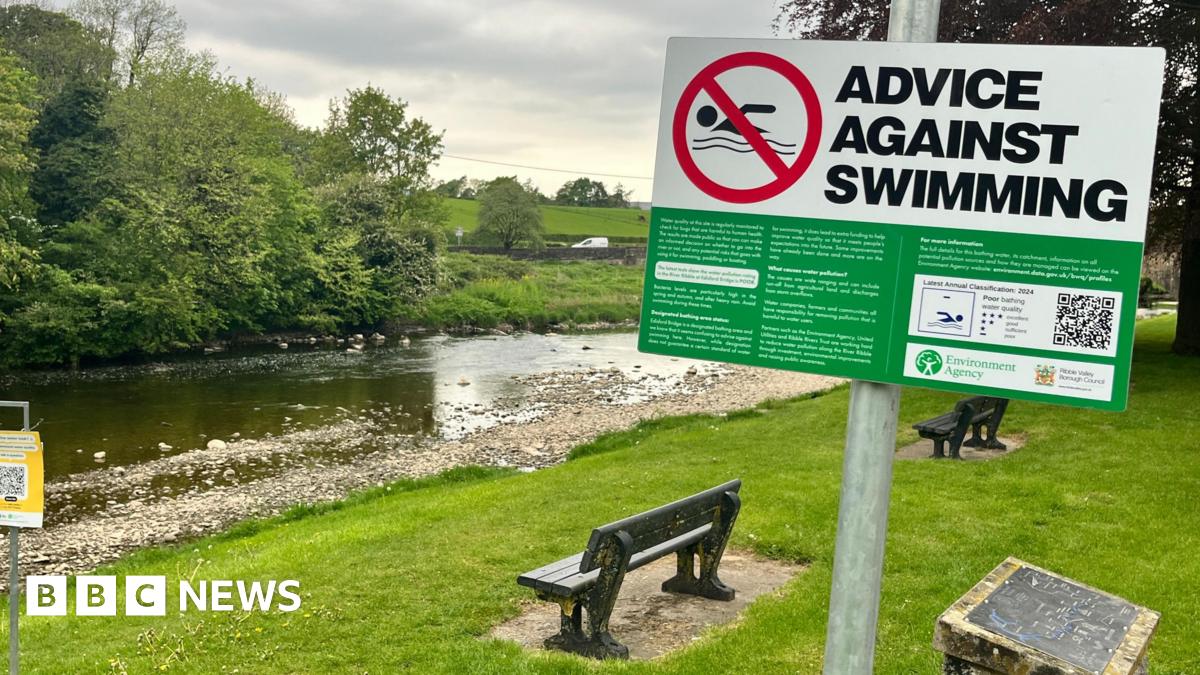 A sign saying Advice Against Swimming posted alongside a river in Lancashire.