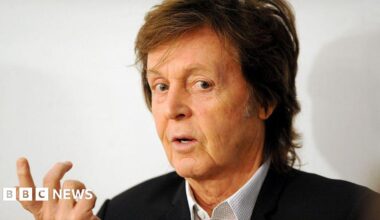 Headshot of musician Paul McCartney, wearing black blazer and open-necked shirt, taken in 2014