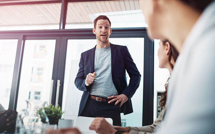 Businessman confidently presenting to a team about AI Businessman confidently presenting to a team about AI