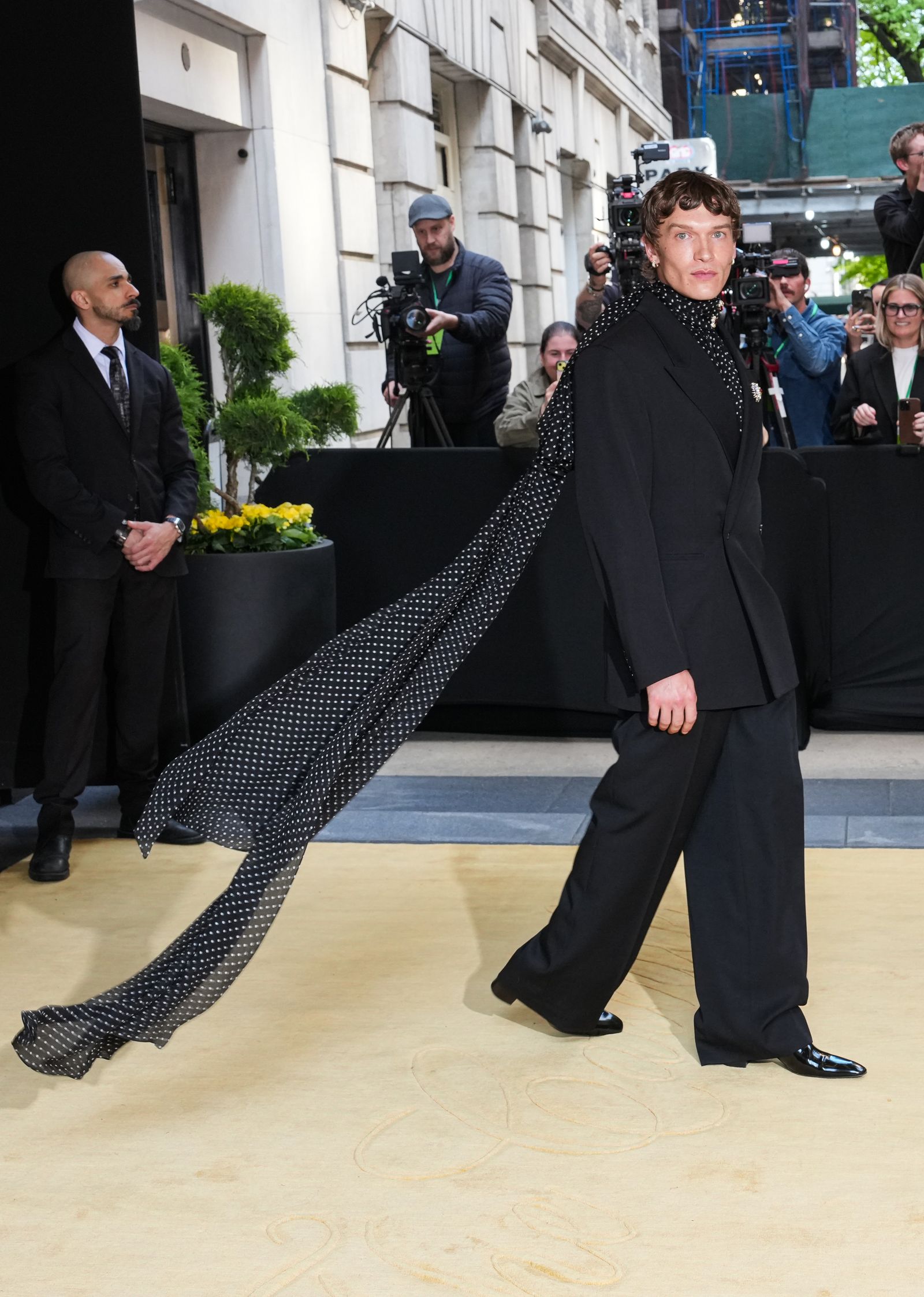 Image may contain Adult Person Clothing Formal Wear Suit Footwear Shoe Coat Photobombing Accessories and Tie