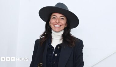 Davina McCall wearing a big hat and smiling.