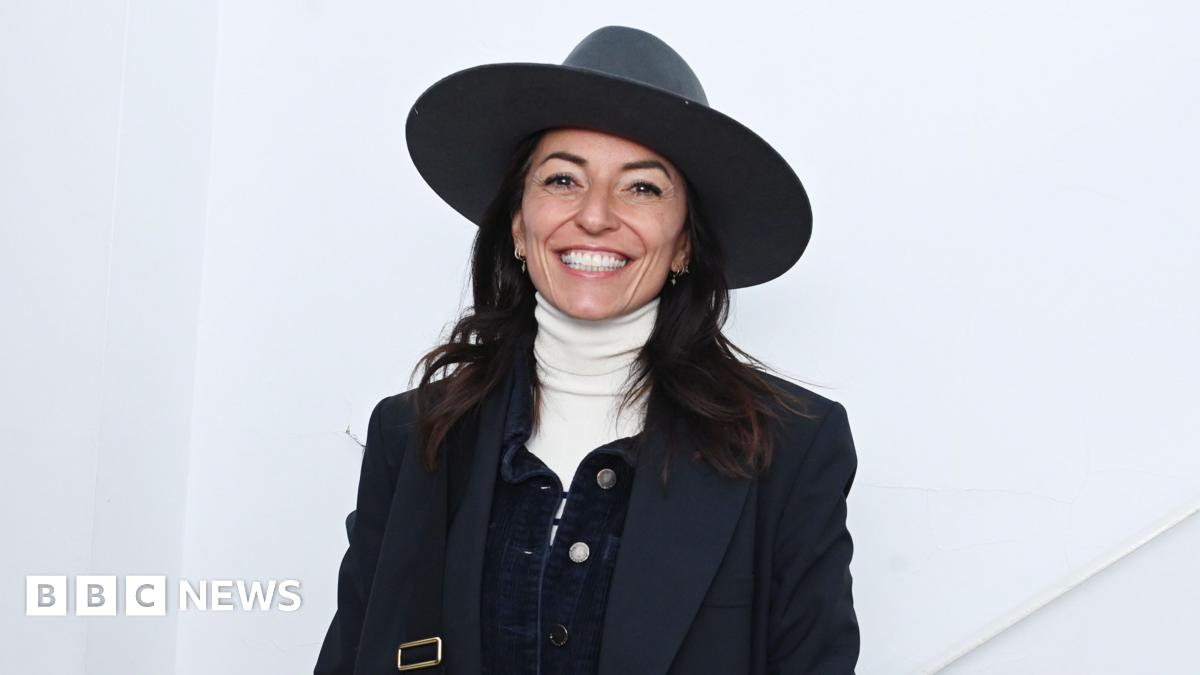 Davina McCall wearing a big hat and smiling.