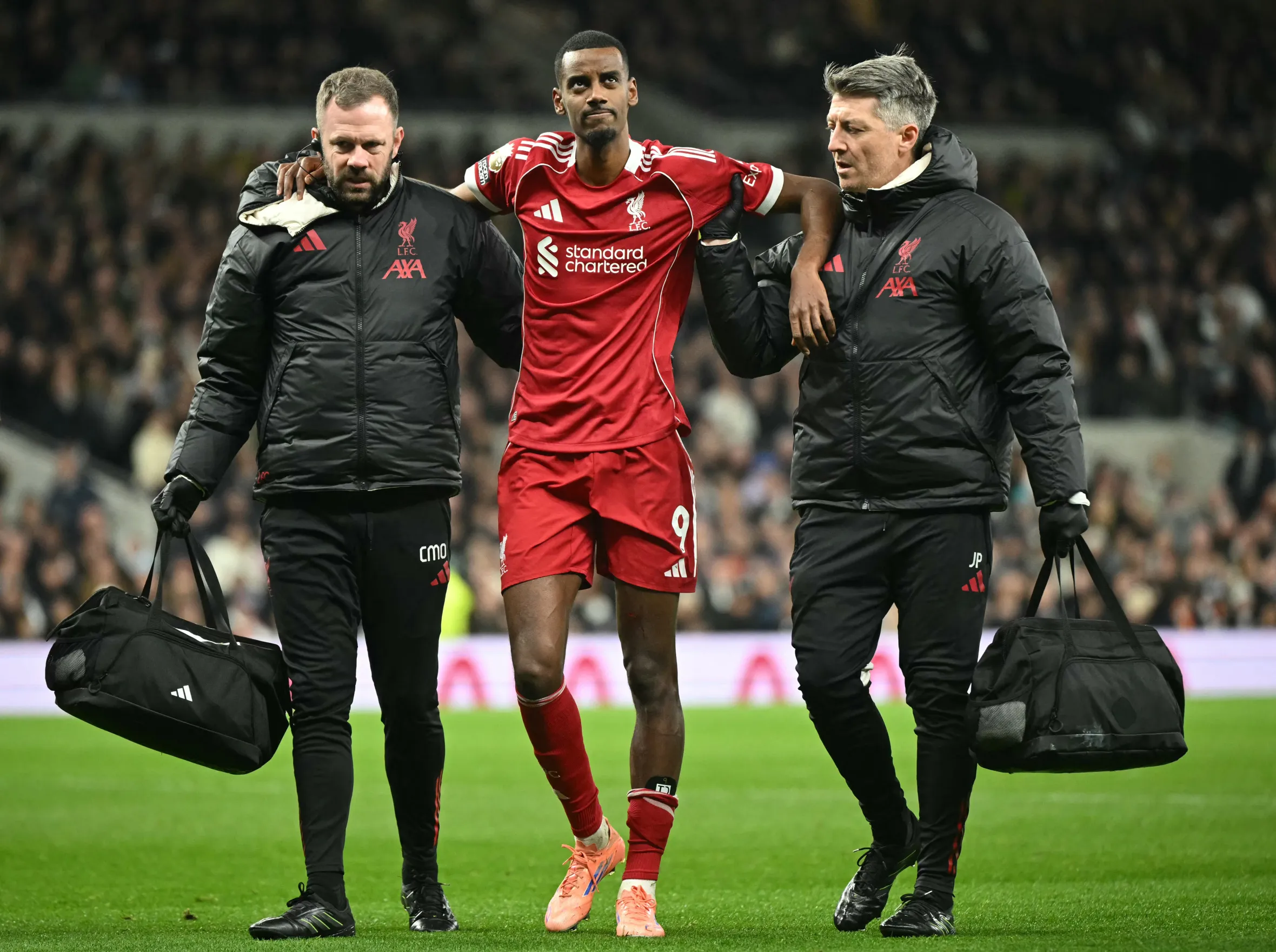 Liverpool striker Alexander Isak is helped off the field by medical staff after picking up an injury.