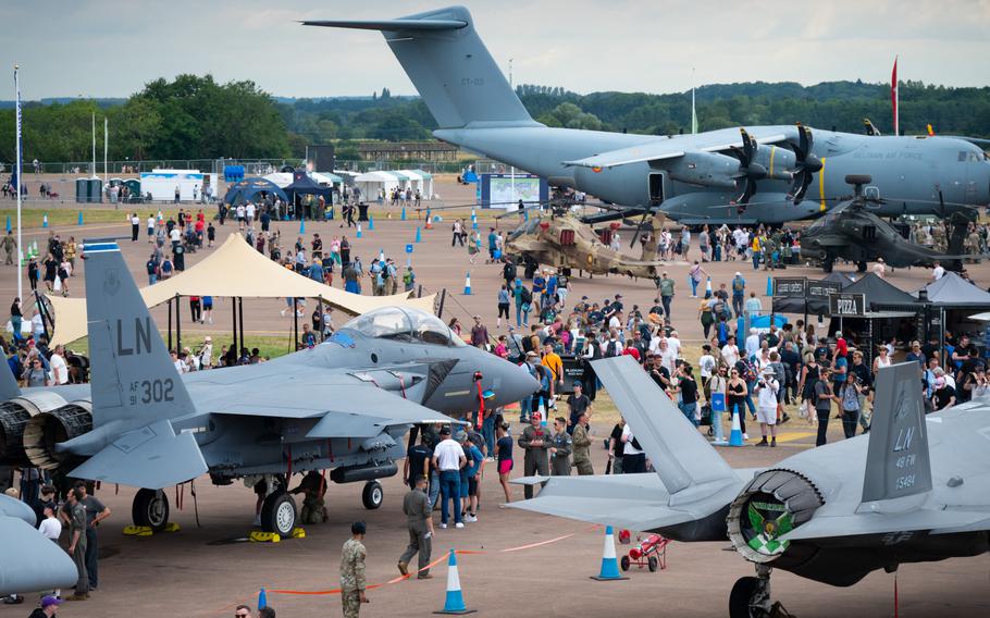 People walk around aircraft sitting on display.