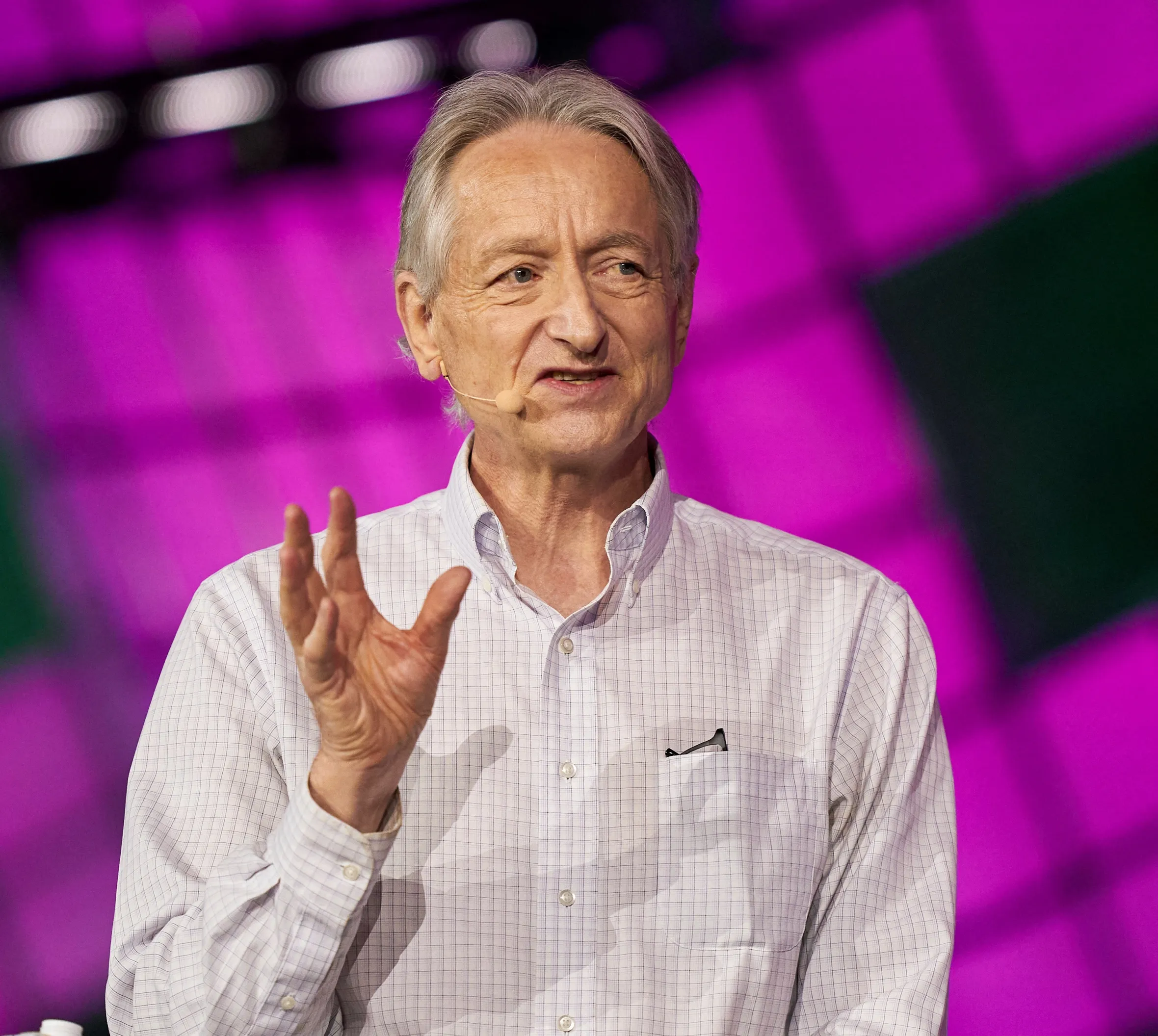 Geoffrey Hinton, wearing a checkered shirt, speaks at the Collision Tech Conference.