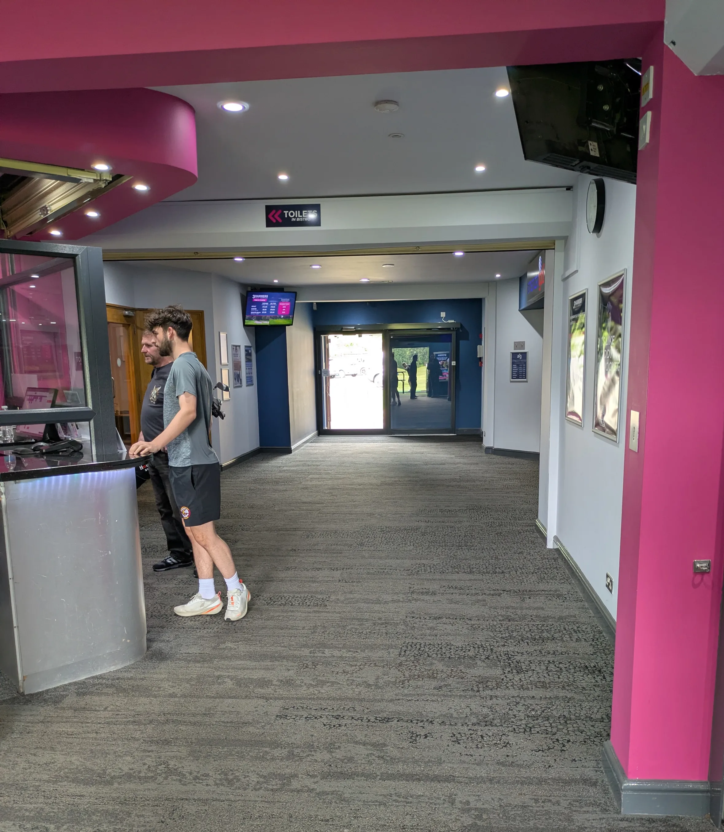 Two men at the counter in the lobby of 3 Hammers Golf Complex in Wolverhampton.
