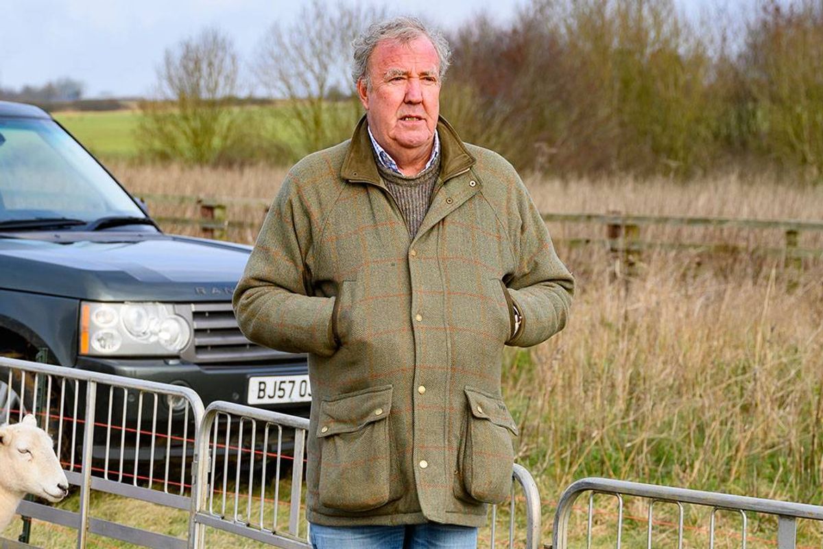 A man stands with his hands in his coat pockets