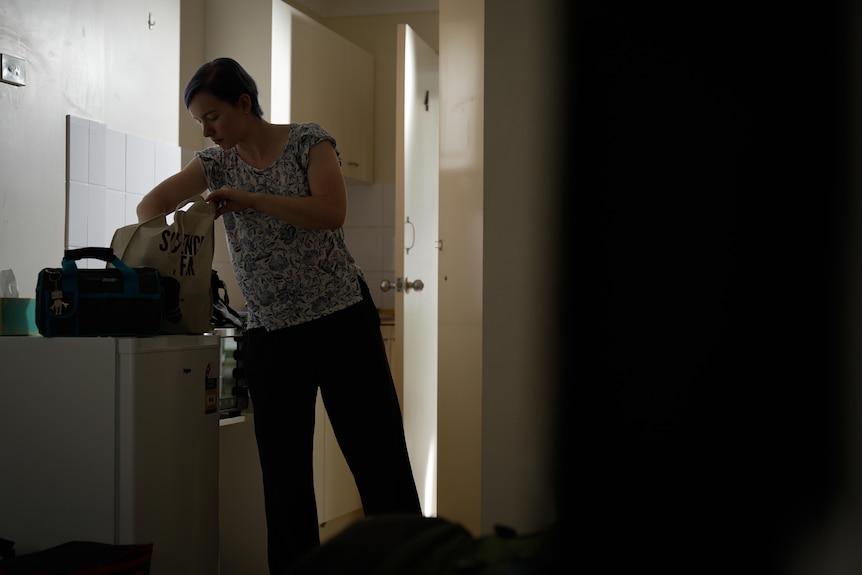 A woman unpacking shopping bags in her kitchen.