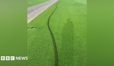 A deep line running across a tennis lawn.