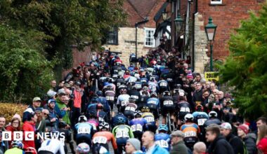 Riders in the Lincoln Grand Prix head up Michaelgate towards the cathedral and Castle Square. Large crowds are standing on both sides of the road.