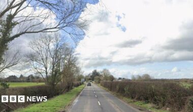 A screenshot taken from Google Maps showing Old Gloucester Road in Staverton. Image shows a country road with grass and hedges on either side.